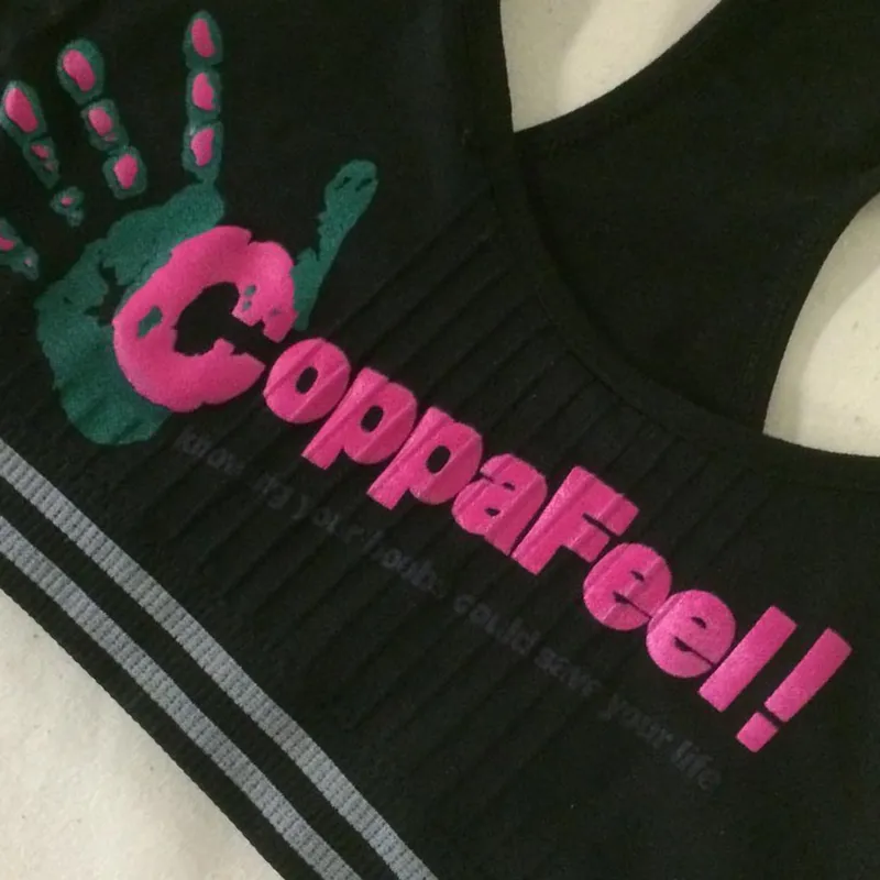 Multi-colour green and pink hand-print logo printed on a black sports top